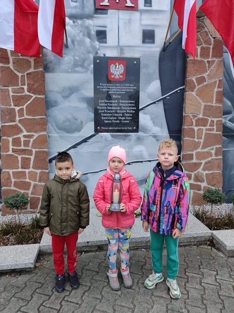 Klasy pierwsze przy tablicy pamiątkowej.